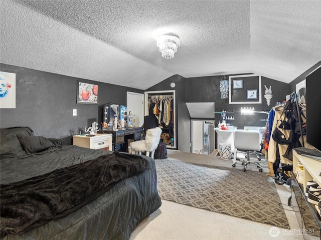 carpeted bedroom featuring a closet, a textured wall, lofted ceiling, a textured ceiling, and a notable chandelier