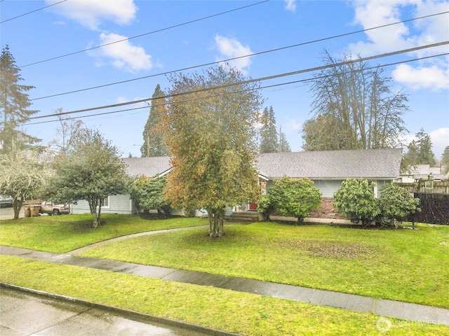 obstructed view of property with a front lawn and brick siding