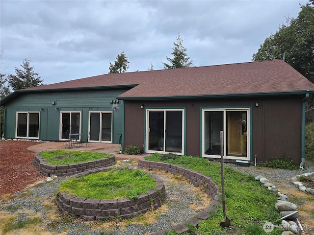 back of house featuring roof with shingles and a patio area