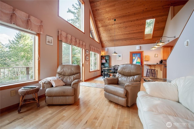 living room featuring a towering ceiling, light wood-style flooring, and a healthy amount of sunlight