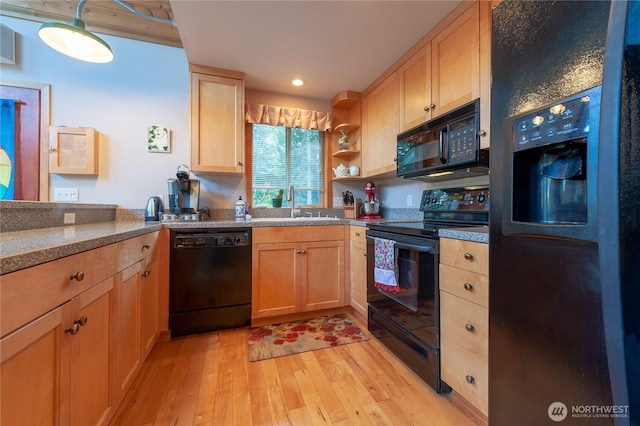 kitchen featuring light brown cabinets, open shelves, a sink, light wood-type flooring, and black appliances