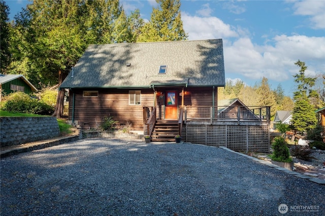 chalet / cabin featuring roof with shingles