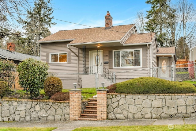 view of front facade with a shingled roof, fence, and a chimney