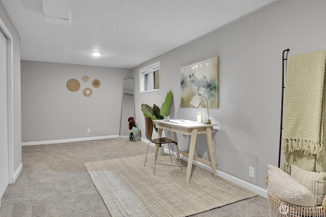 office space with light carpet, a textured ceiling, and baseboards