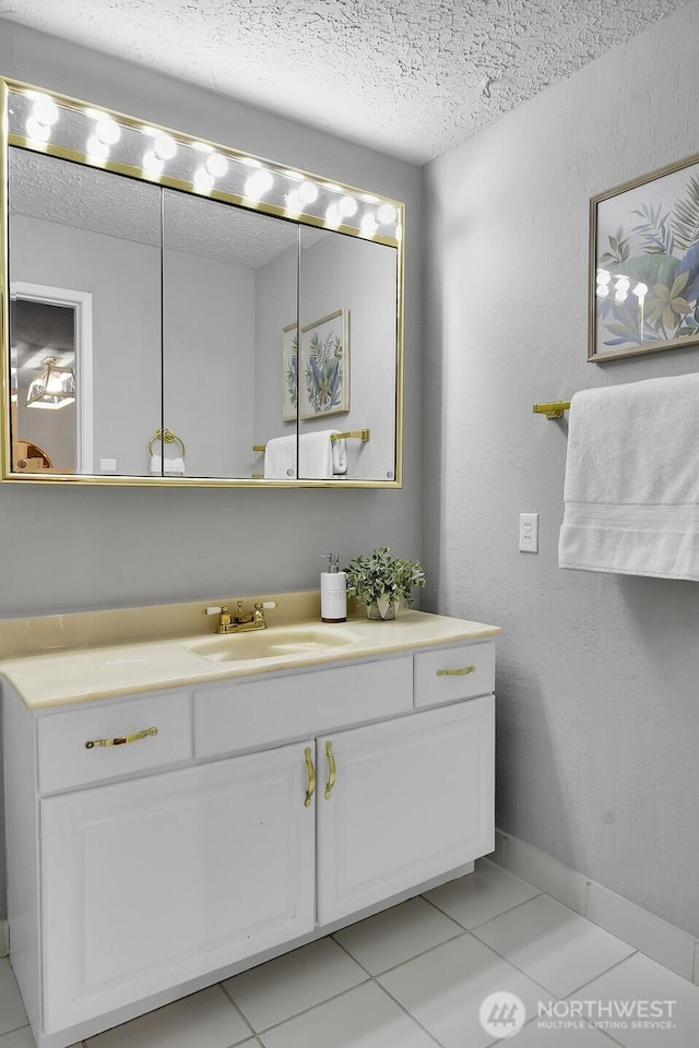 bathroom featuring baseboards, a textured ceiling, vanity, and tile patterned floors