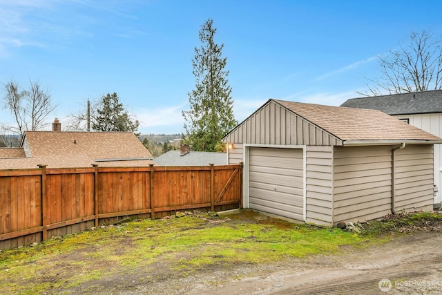 detached garage with driveway and fence