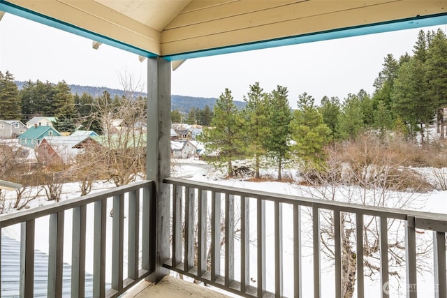 view of snow covered back of property