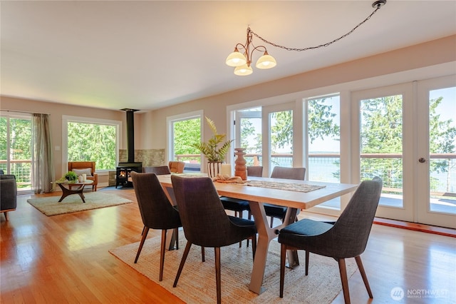 dining space with light wood-style floors and a wood stove