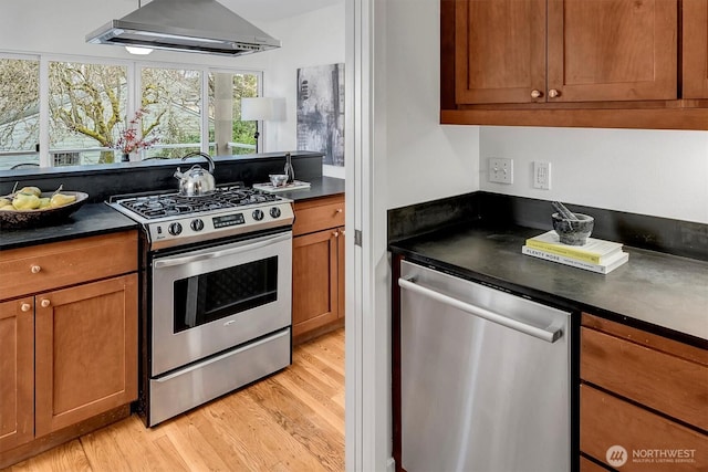 kitchen with dark countertops, extractor fan, brown cabinets, and stainless steel appliances