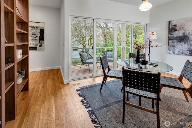 dining space with light wood-style floors, visible vents, baseboards, and french doors