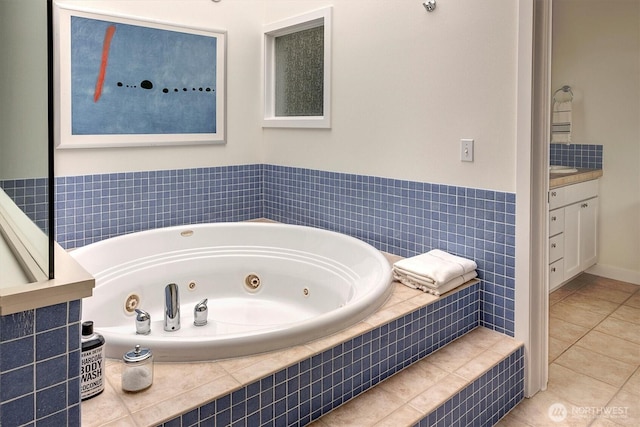 bathroom with a jetted tub, vanity, and tile patterned floors