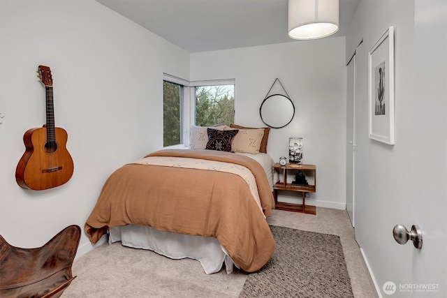 bedroom featuring light carpet and baseboards