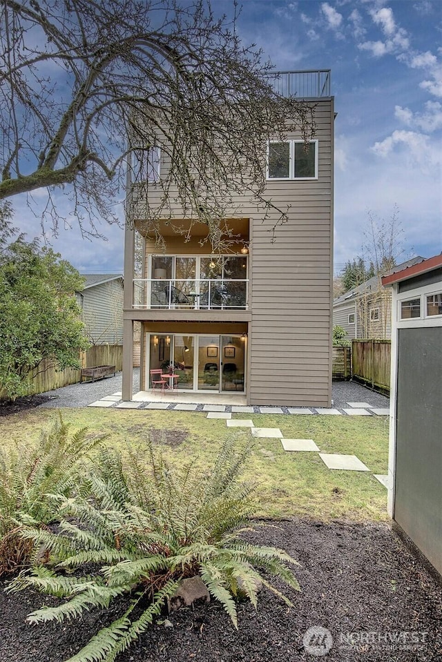 back of property featuring a yard, a patio area, and fence