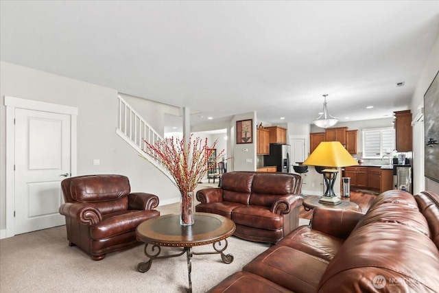 living area featuring recessed lighting, stairway, and light colored carpet