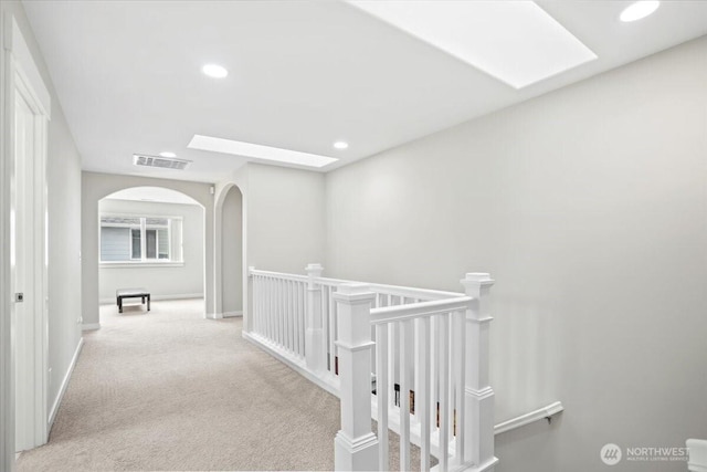 hallway featuring a skylight, carpet flooring, recessed lighting, and visible vents