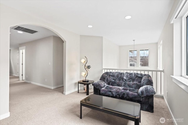 living room featuring carpet, visible vents, baseboards, recessed lighting, and arched walkways