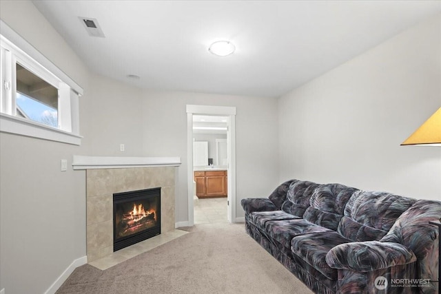 living room with light carpet, visible vents, a fireplace, and baseboards