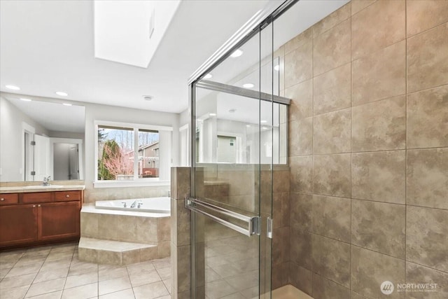 bathroom with a stall shower, a garden tub, a skylight, and vanity