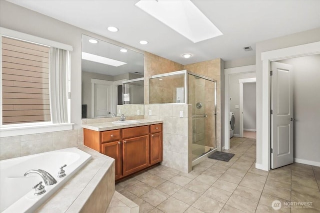 bathroom with visible vents, a shower stall, a garden tub, a skylight, and vanity