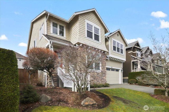 view of front of property featuring a front lawn, an attached garage, fence, and driveway