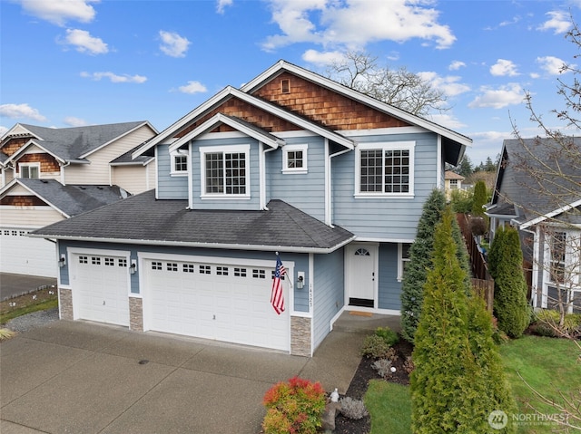 craftsman-style home with a garage, driveway, roof with shingles, and stone siding