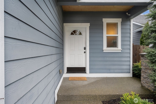 view of exterior entry featuring fence