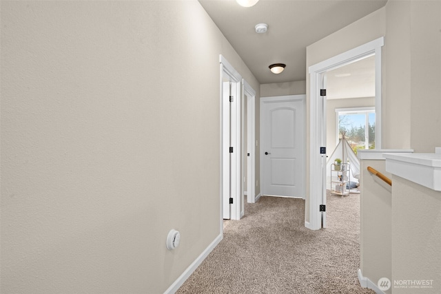 hallway with carpet floors and baseboards