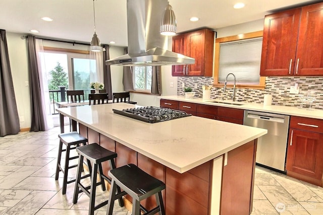 kitchen featuring a breakfast bar, island exhaust hood, stainless steel appliances, pendant lighting, and a sink