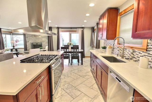 kitchen with light stone counters, a sink, appliances with stainless steel finishes, tasteful backsplash, and island exhaust hood