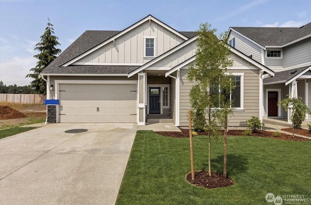 view of front of house with driveway, roof with shingles, an attached garage, a front lawn, and board and batten siding