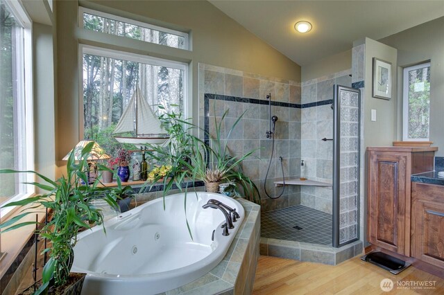 16 Koala Ln, Pacific Beach, WA 98571 - bathroom featuring vaulted ceiling, a stall shower, wood finished floors, and a jetted tub