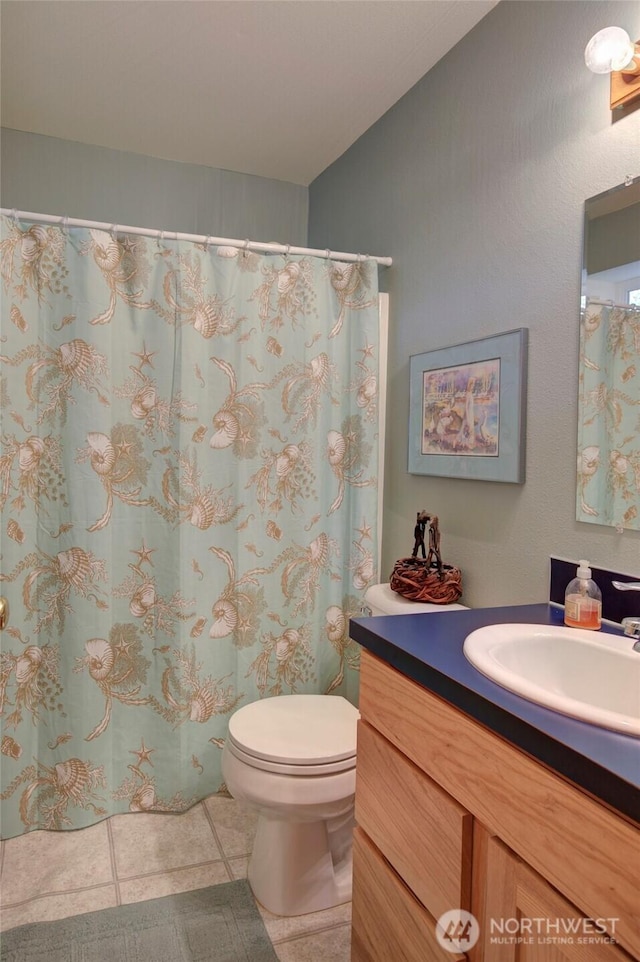 16 Koala Ln, Pacific Beach, WA 98571 - full bath featuring tile patterned floors, vanity, vaulted ceiling, and toilet