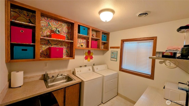 laundry room with laundry area, separate washer and dryer, a sink, visible vents, and baseboards