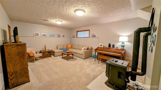 carpeted living area featuring vaulted ceiling, a textured ceiling, and wainscoting