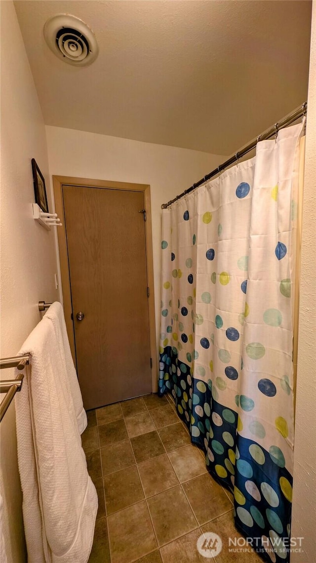 bathroom with tile patterned flooring, visible vents, and a shower with shower curtain