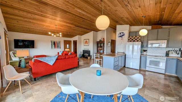 dining area featuring lofted ceiling, wooden ceiling, and a notable chandelier