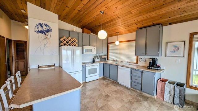 kitchen featuring light countertops, white appliances, decorative light fixtures, and gray cabinetry