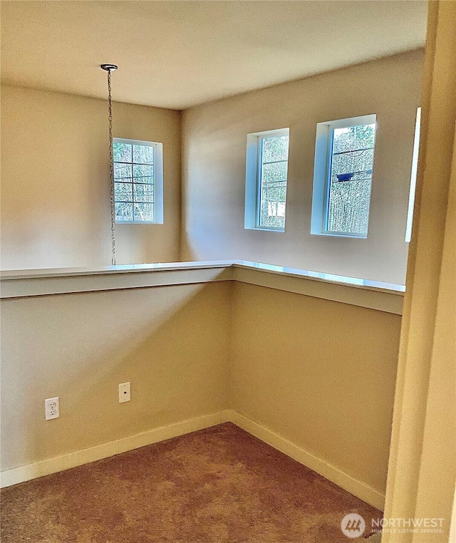 empty room featuring a wealth of natural light and baseboards