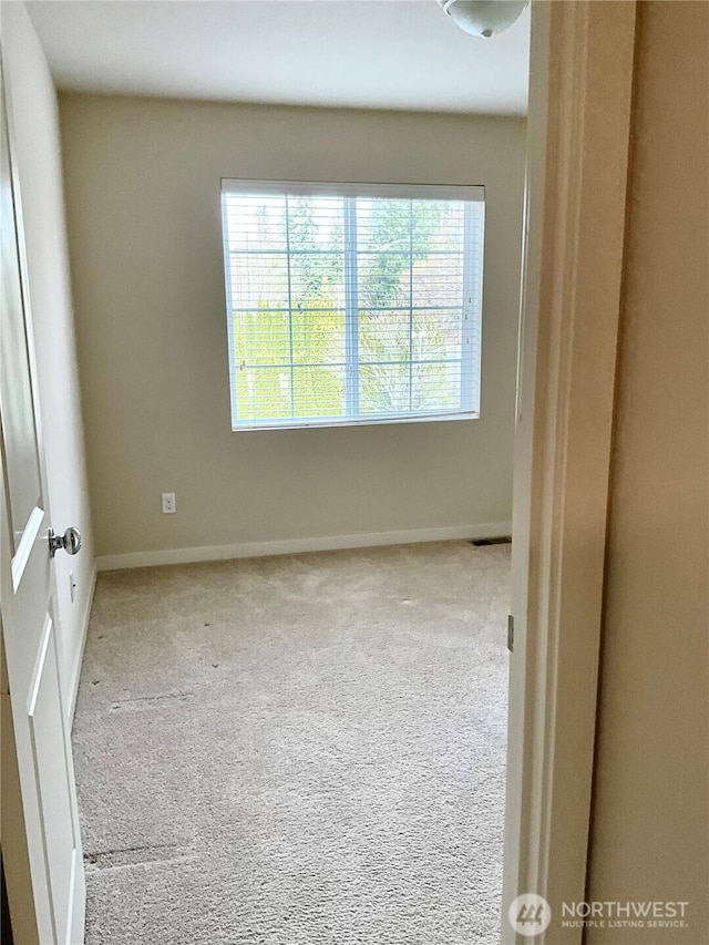 carpeted empty room with baseboards