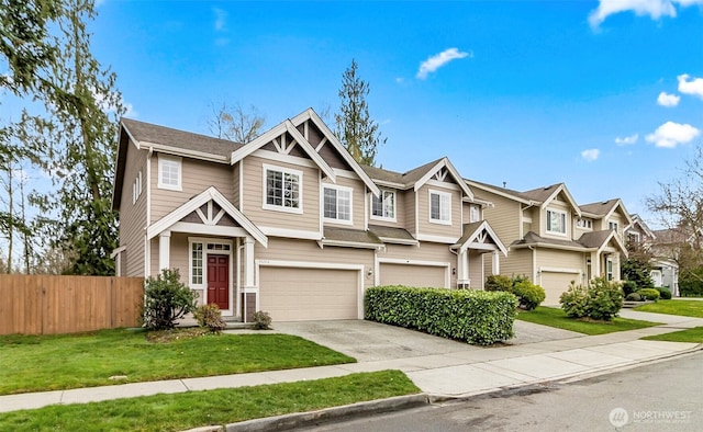 view of front of house featuring a front lawn, driveway, fence, a residential view, and an attached garage