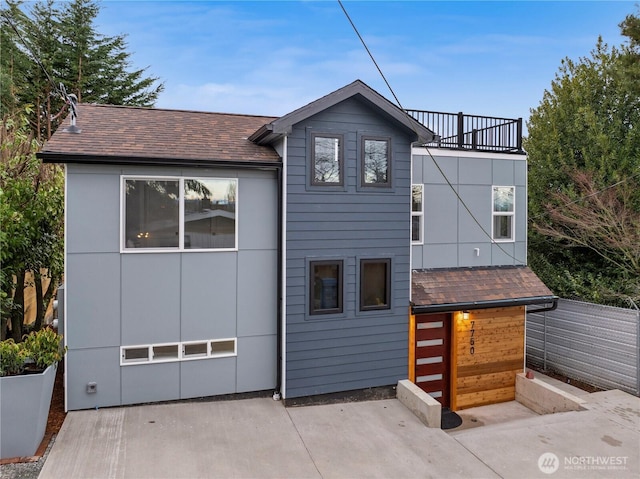 view of front of home featuring a shingled roof and a balcony