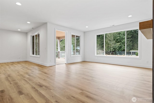 unfurnished room featuring light wood-type flooring, baseboards, a wealth of natural light, and recessed lighting