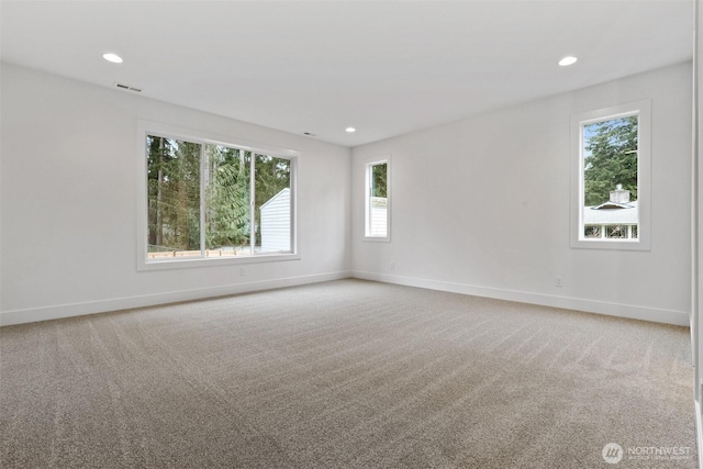 empty room with carpet floors, visible vents, baseboards, and recessed lighting