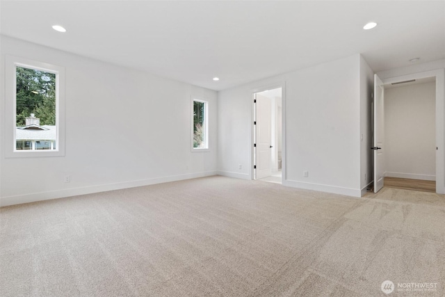 unfurnished room featuring recessed lighting, baseboards, and light colored carpet