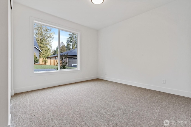 empty room featuring carpet floors and baseboards