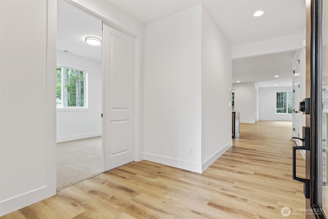 hallway featuring light wood-type flooring, baseboards, and recessed lighting