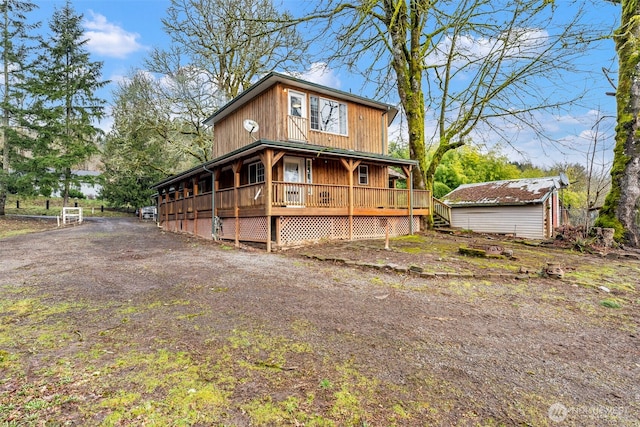 view of front of home featuring a storage shed, a wooden deck, and an outdoor structure