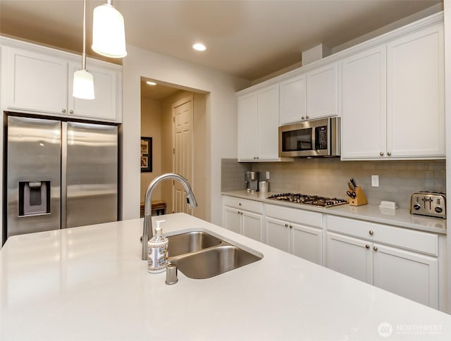 kitchen featuring light countertops, appliances with stainless steel finishes, a sink, and white cabinetry