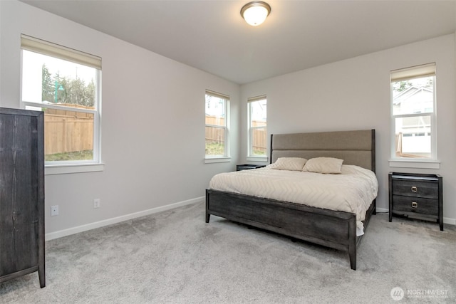 bedroom with light carpet, baseboards, and multiple windows