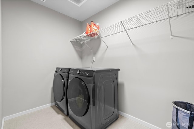 laundry room with light carpet, laundry area, baseboards, and washing machine and clothes dryer